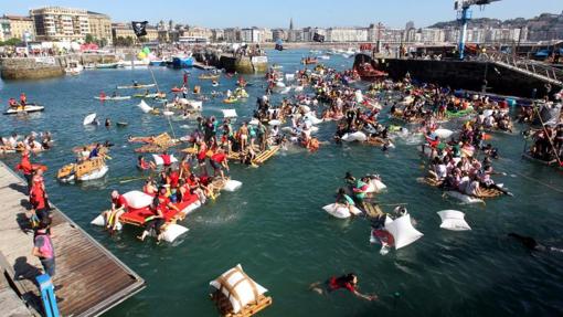 Centenares de jóvenes participan en las barcas construidas para la ocasión en el tradicional abordaje pirata de la Semana Grande donostiarra