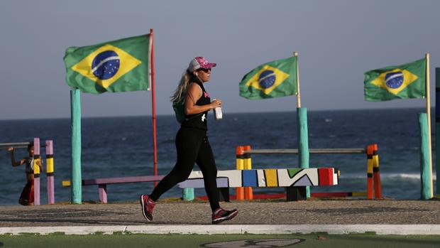 Una mujer practica deporte en la playa de Barra da Tijuca