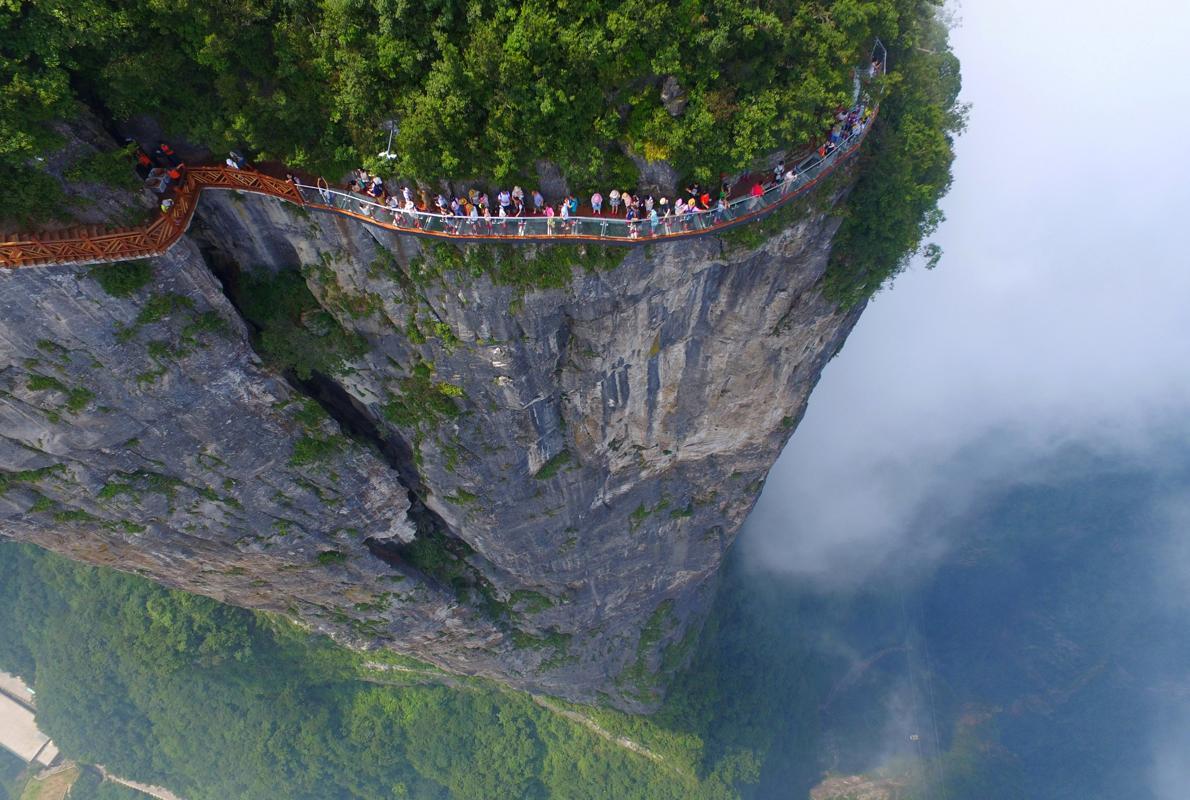 Turistas caminan por la nueva plataforma de cristal de Zhangjiajie, en la provincia de Hunan, China