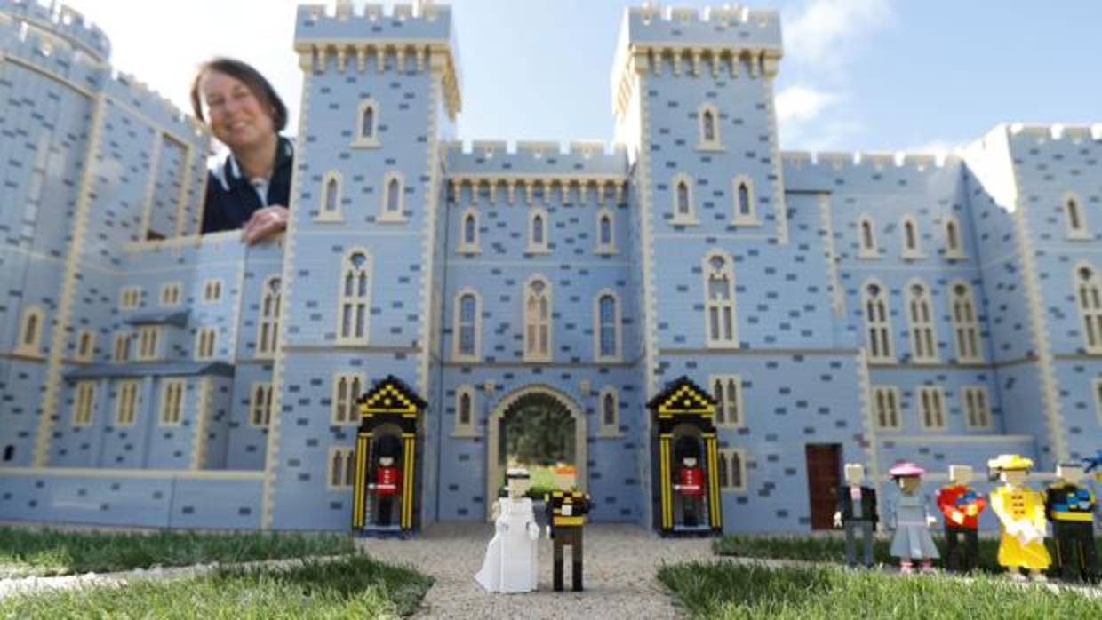 La diseñadora de esta atracción Paula Laughton posa junto al Castillo de Windsor y los novios construidos con bloques de Lego