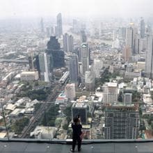Una mujer toma fotos de la ciudad desde el mirador del rascacielos King Power Mahanakhon