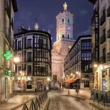 La torre de la catedral destaca sobre las calles de una ciudad bellamente iluminada