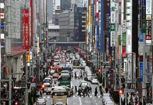 Peatones cruzan una céntrica calle de Tokio entre el denso tráfico