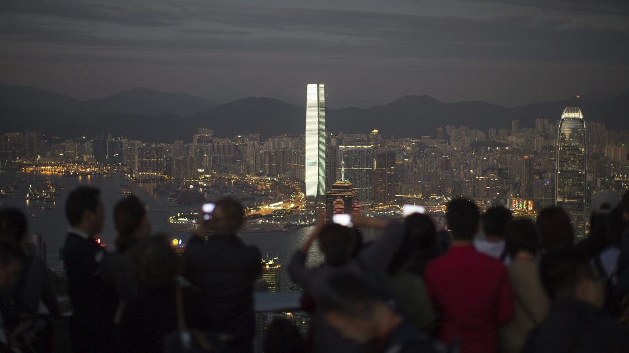 Varias personas admiran las vistas desde la cumbre Victoria en Hong Kong