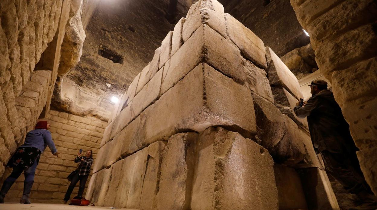 Turistas toman fotografías en la cámara funeraria y el sarcófago del Rey Djoser dentro de la pirámide escalonada de Saqqara,