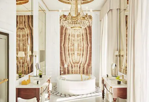 Baño de la Suite Real, con una enorme bañera redonda de mármol Michelangelo pulido presidida por un mural de Onix Vida