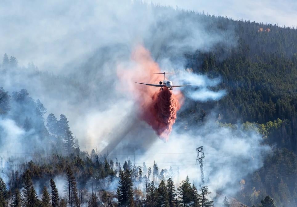 Un MD-87 rocía retardante sobre una línea de alta tensión en California.