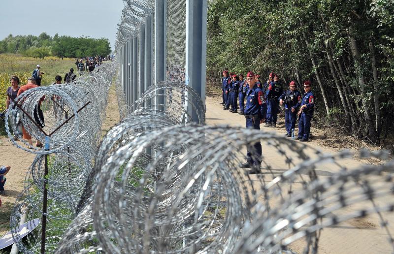 Migrantes y refugiados caminan al lado de la valla entre Serbia y Hungría cerca de Horgos, Serbia (2015)
